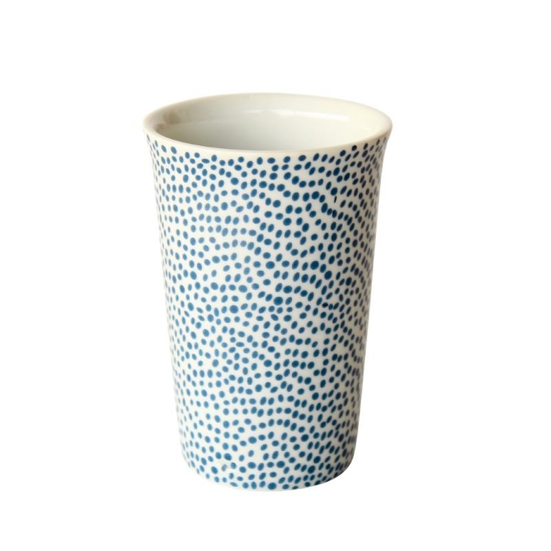 Ceramic cup with blue dot pattern on a white background