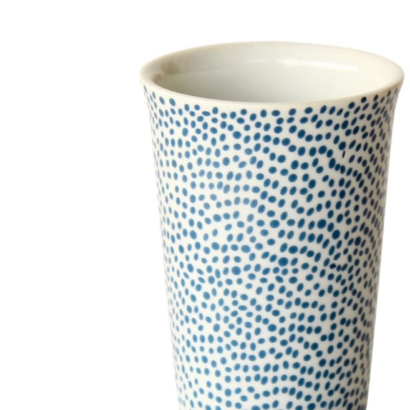 Ceramic tumbler with blue dot pattern on a white background