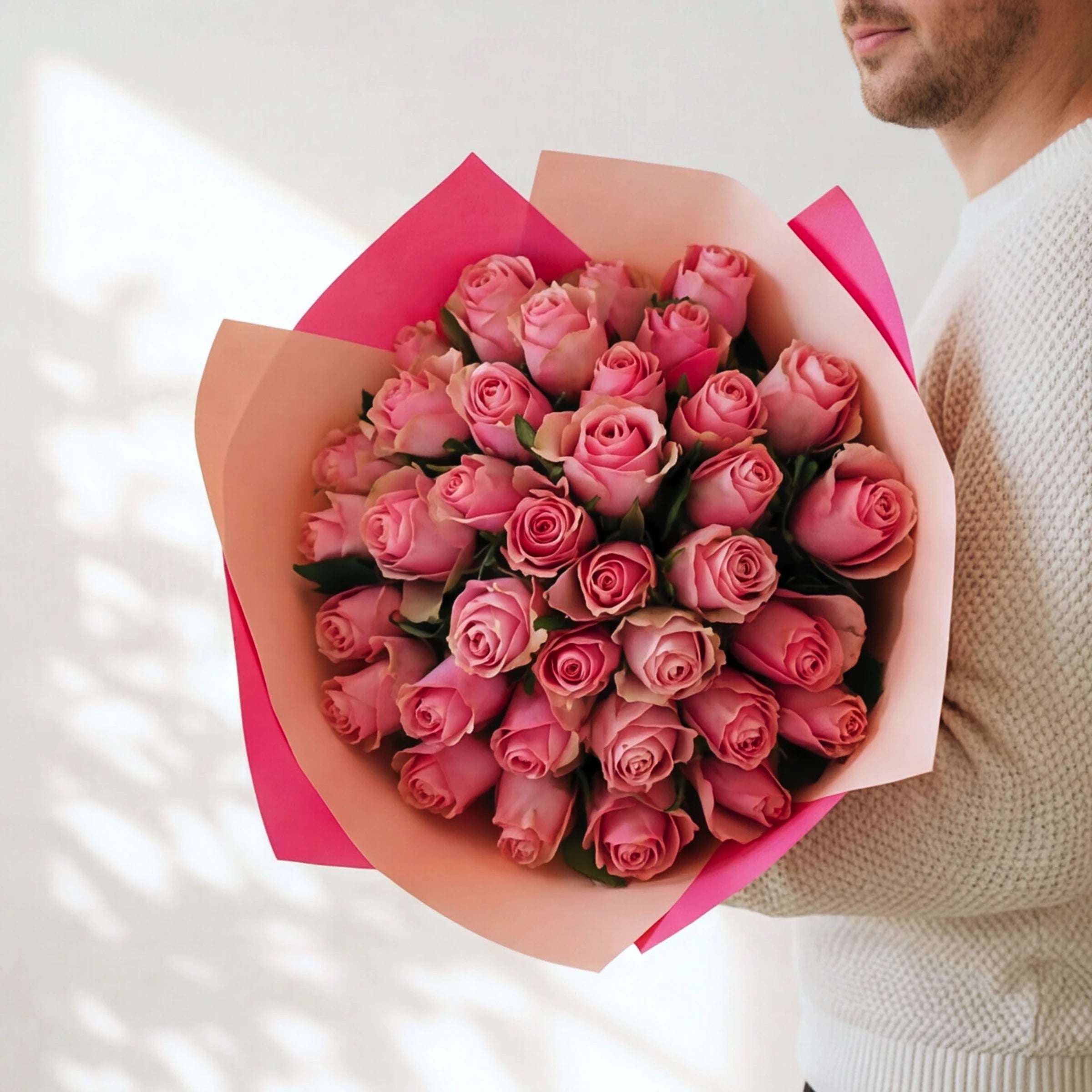 The largest Bonbon, three dozen pink roses in a two-tone pink wrap, held by a Fabulous Flowers florist