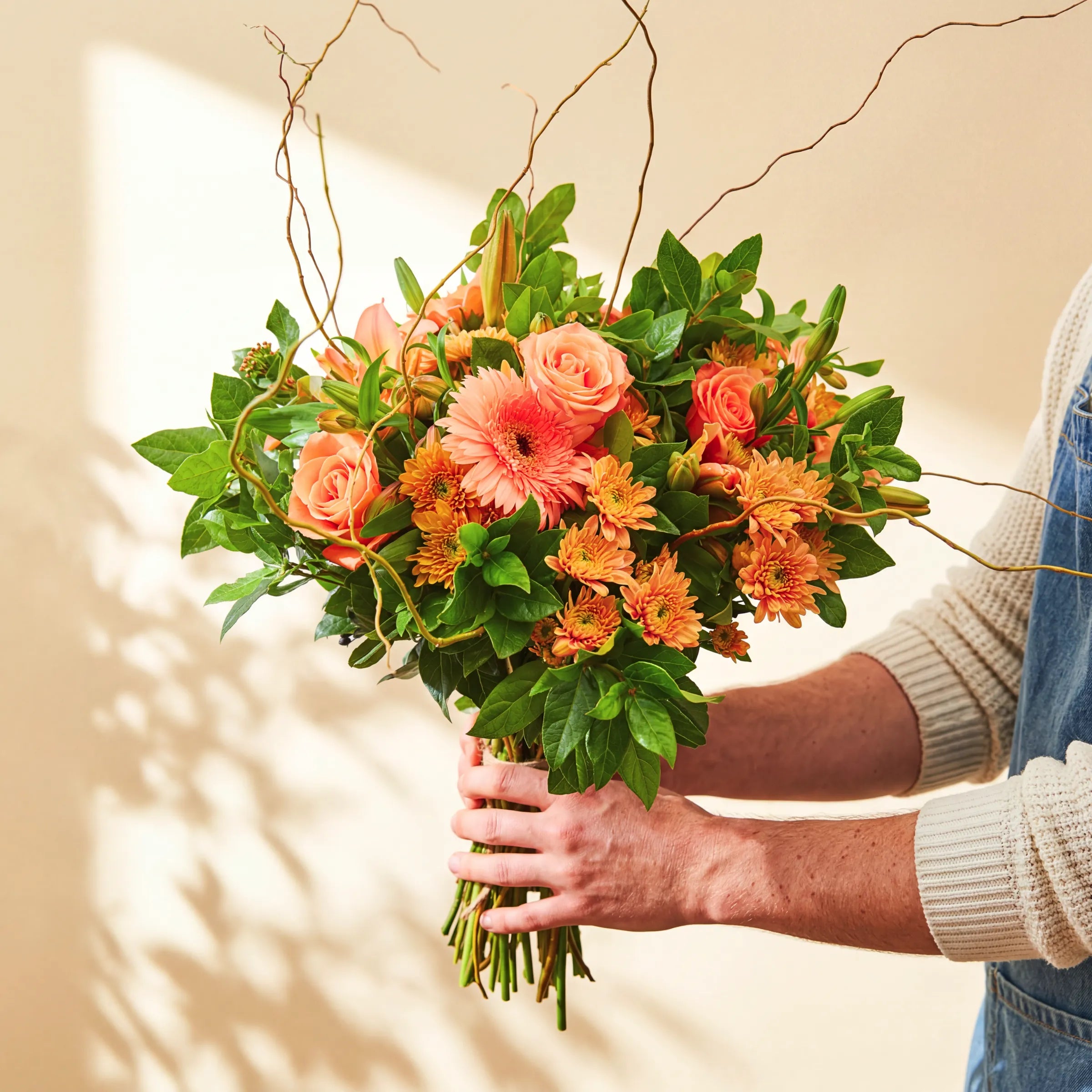 Hand-tied Bright Sunshine Bouquet of peach roses, coral gerbera daisies, orange chrysanthemums and asiatic lily buds with lush greenery