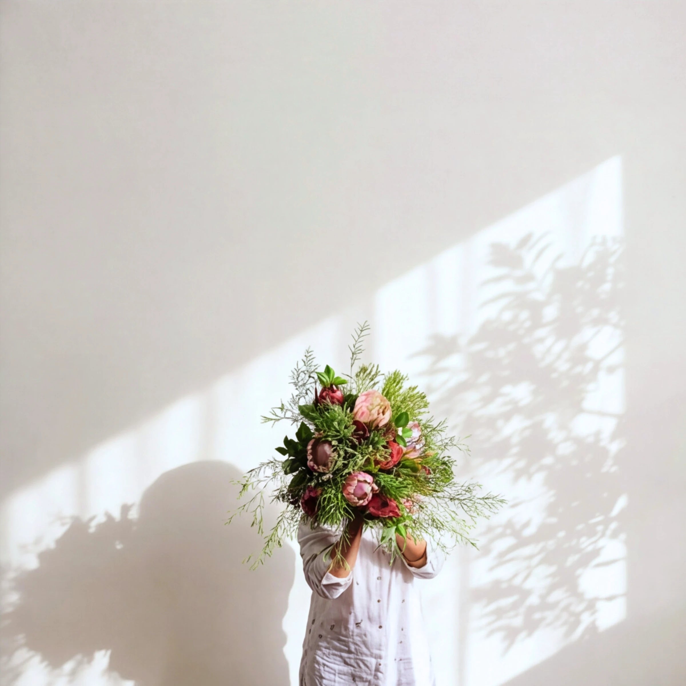 The Cape Town Protea Bouquet of proteas and fynbos, held up in soft sunlight