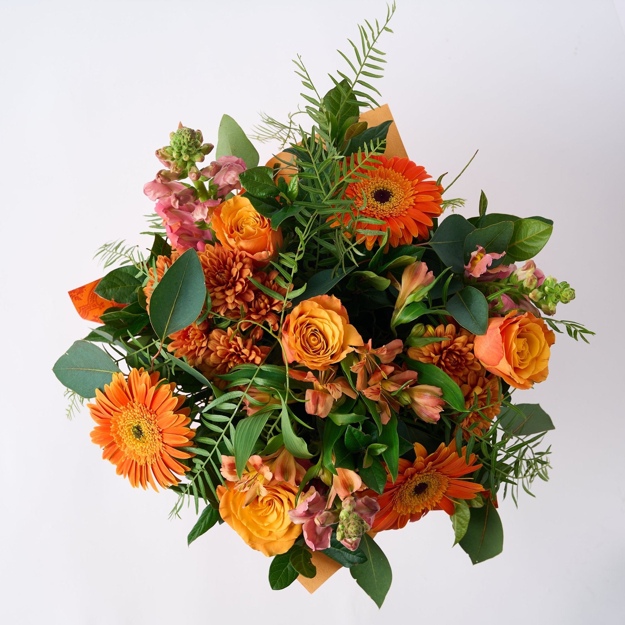 Top view of the Celebrate Flower Arrangement showcasing a beautiful mix of orange flowers and lush greenery.