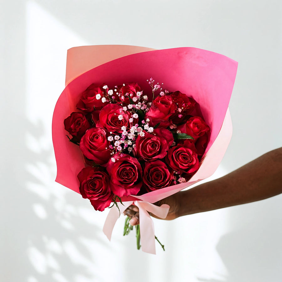 Cerise Crush bouquet of red roses with pink and white gypsophila, wrapped in cerise paper with a pink ribbon