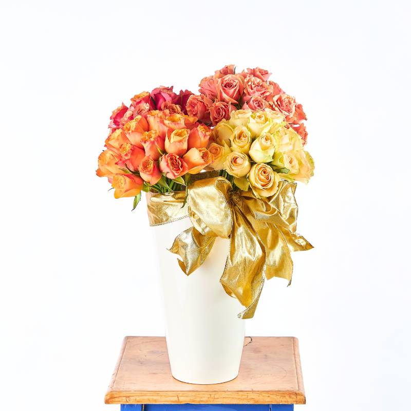 Cherry Elegance rose arrangement in white vase with gold ribbon — coral, orange and yellow roses | Fabulous Flowers and Gifts