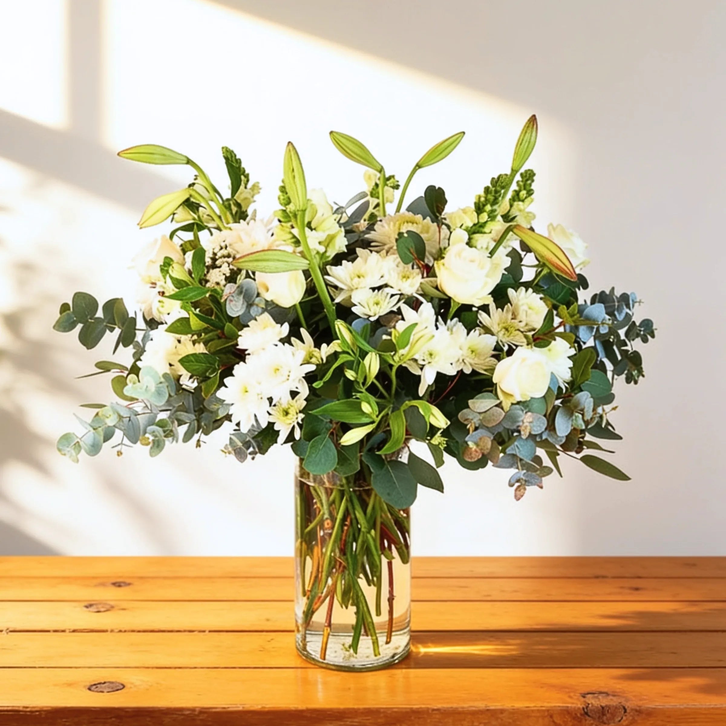Classic white flower arrangement of white roses, chrysanthemums, lilies and eucalyptus in a glass vase, Fabulous Flowers