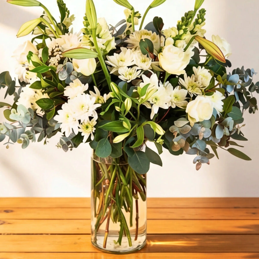 Classic white flower arrangement of white roses, lilies, chrysanthemums and eucalyptus in a glass vase, Cape Town florist