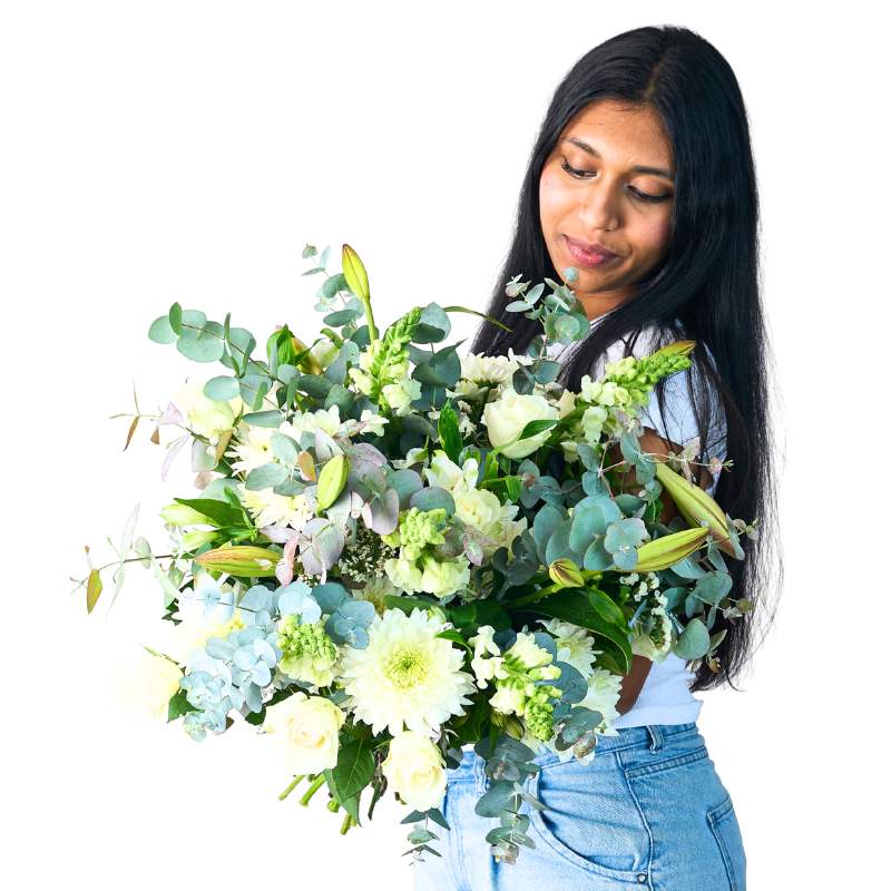 Woman holding a large bouquet of green and white flowers against a white background