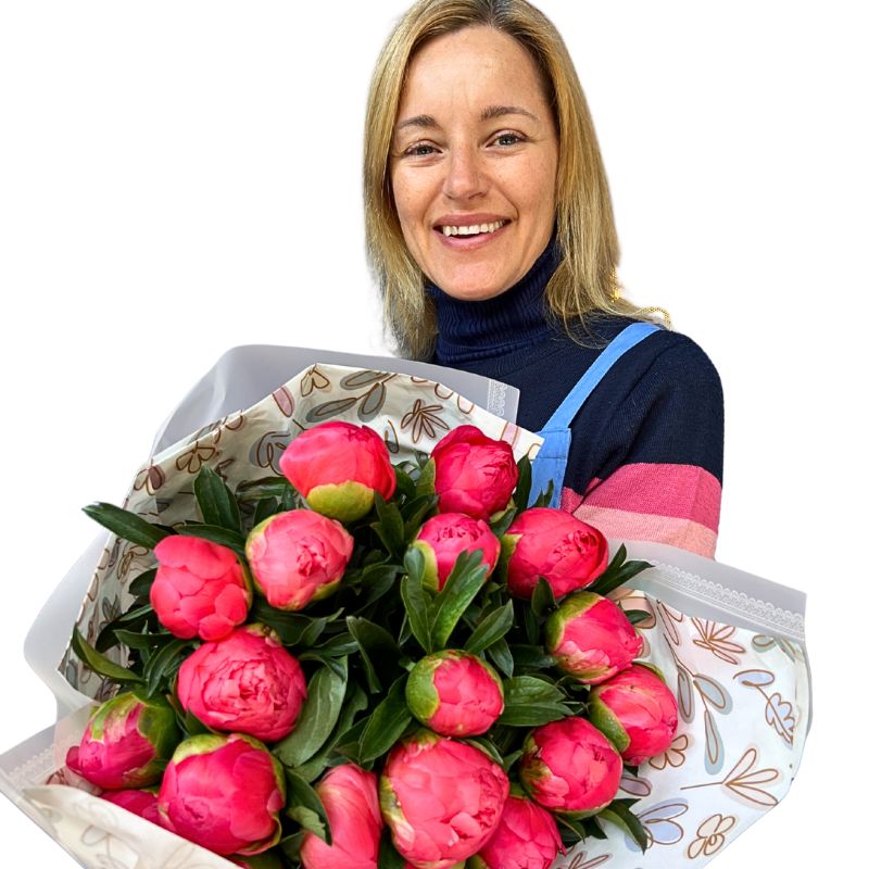 Woman holding a bouquet of pink peony flowers against a white background