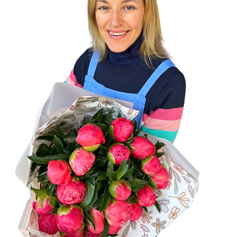 Woman holding a bouquet of pink peony flowers against a white background