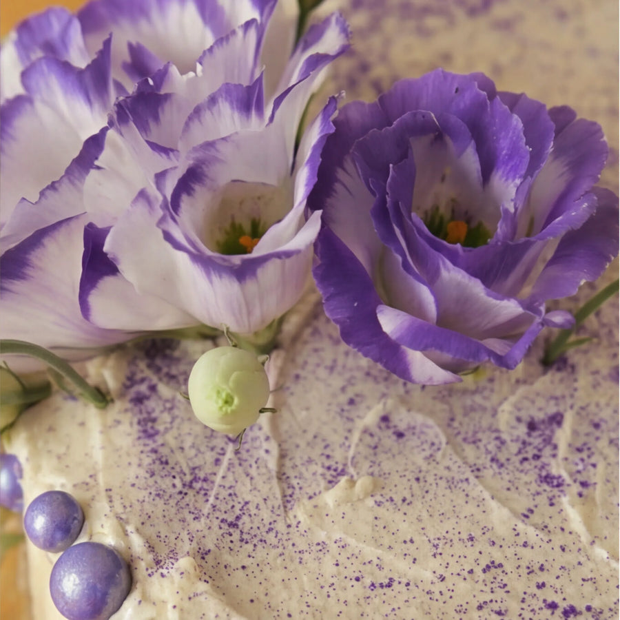 Macro close-up of bicolour purple lisianthus blooms on the Creamy Violet Dream Cake by Fabulous Flowers