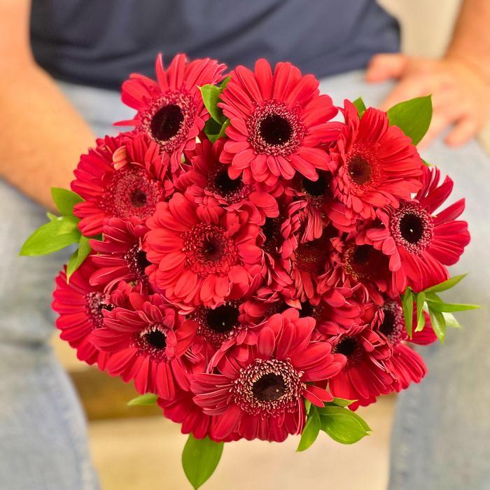 Crimson Kiss Gerbera Daisy Bouquet – bold red gerbera daisies with fresh greenery, hand-held by Fabulous Flowers & Gifts