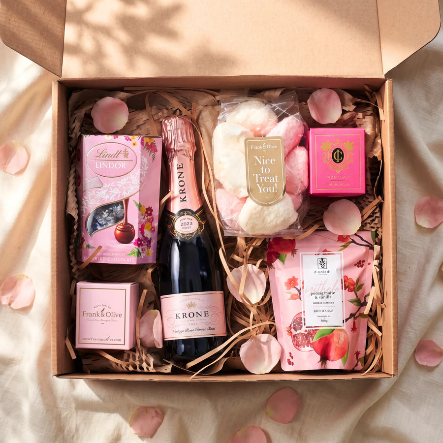 Top view of Daydream Delight Gift Box with Krone Vintage Rose 2023, Lindt Lindor, Frank and Olive marshmallows, Cape Island Wild Coast and Dinaledi pomegranate vanilla bath salt 300g