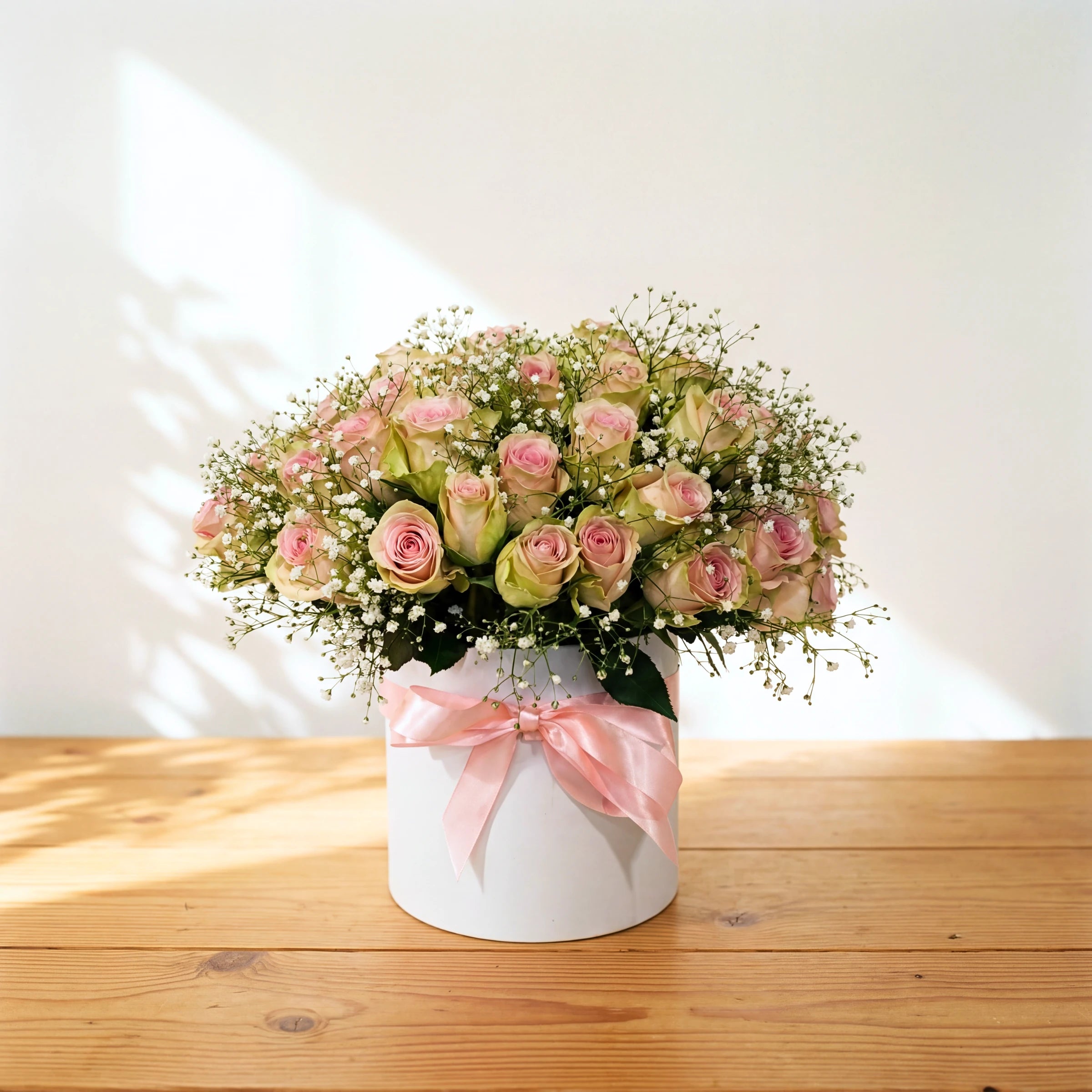 Duchess flowers in a box, pink roses and baby's breath in a white hatbox with a pink satin bow
