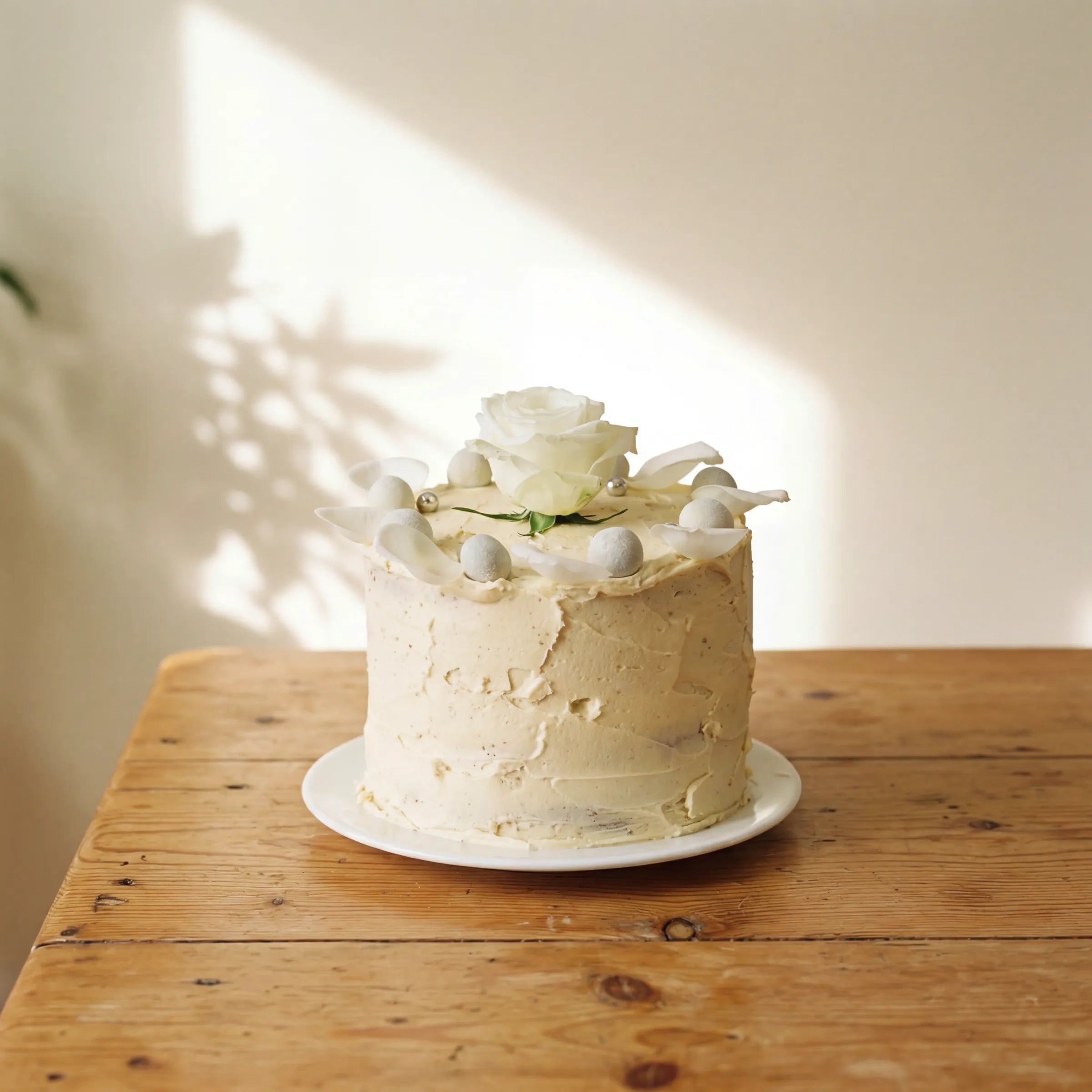 Elegant Rose Celebration Cake with white rose and silver pearls on white plate by Fabulous Flowers Cape Town since 1999