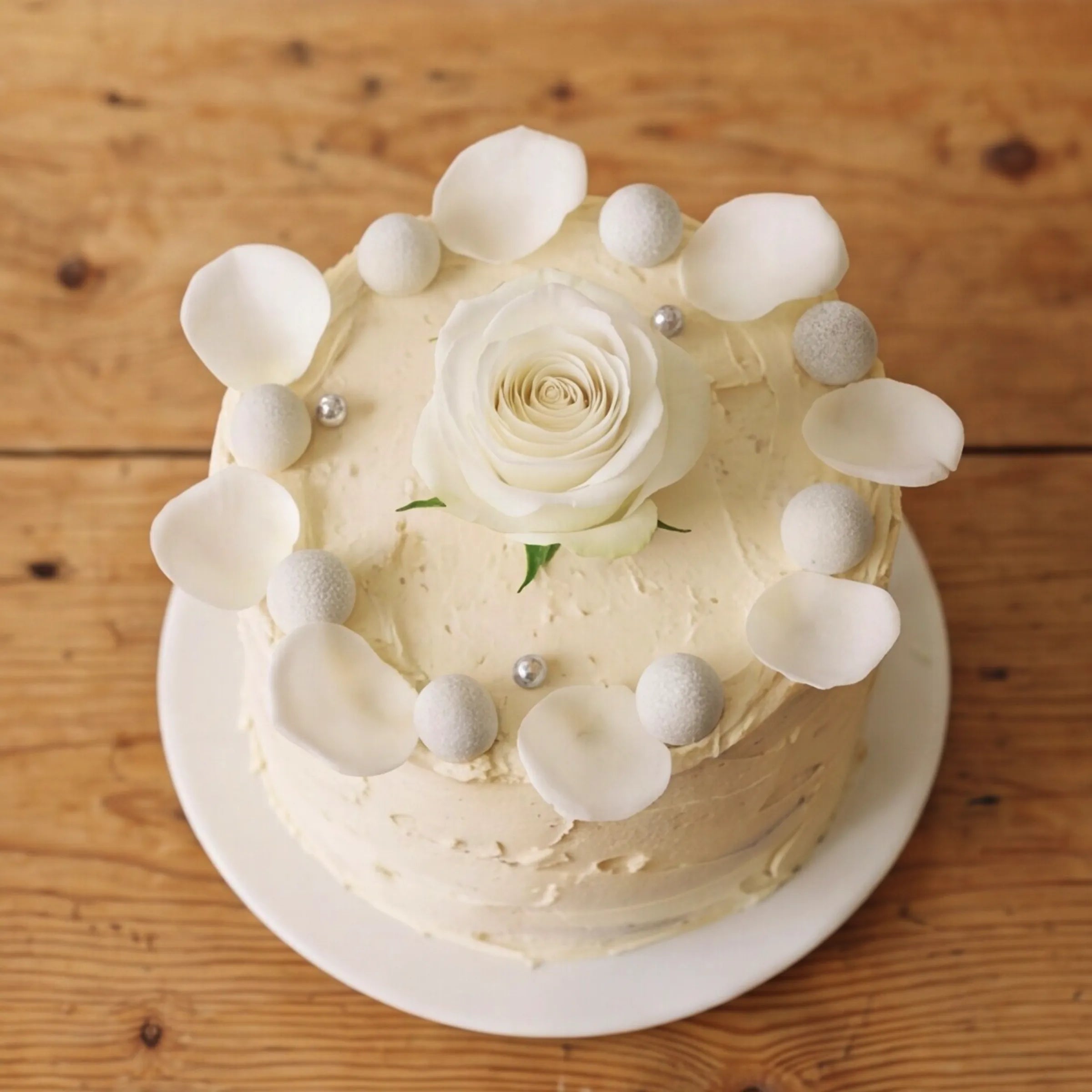 Close-up of white rose centre and silver pearl crown on Elegant Rose Celebration Cake by Fabulous Flowers
