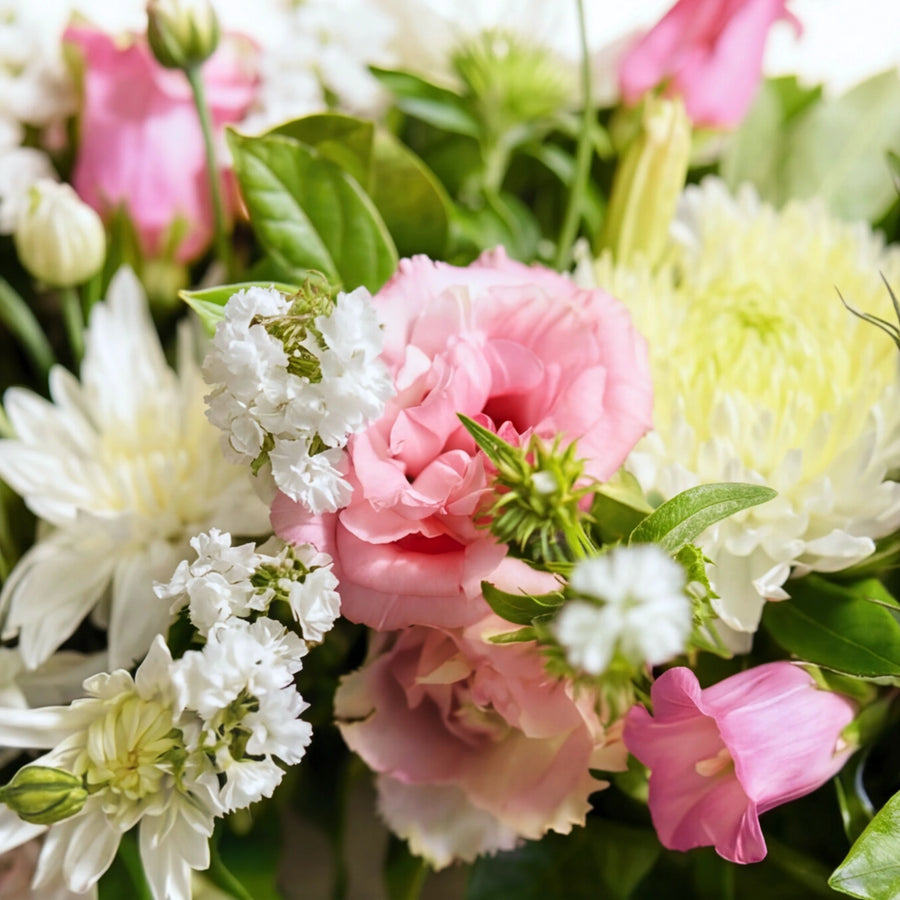 Close up of pink lisianthus, white chrysanthemums and statice in the Eternal Spring wreath