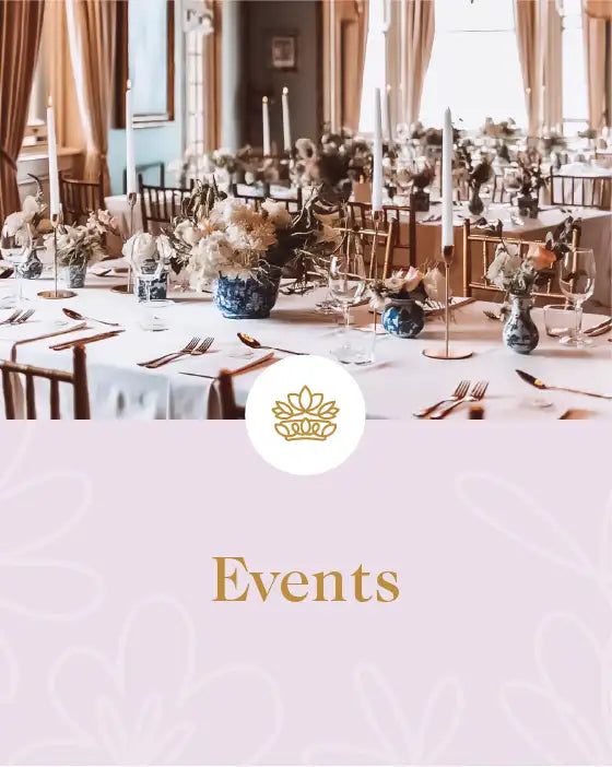 Elegant event setup with tables adorned with floral arrangements and candles in a sophisticated venue. Fabulous Flowers and Gifts. Events.