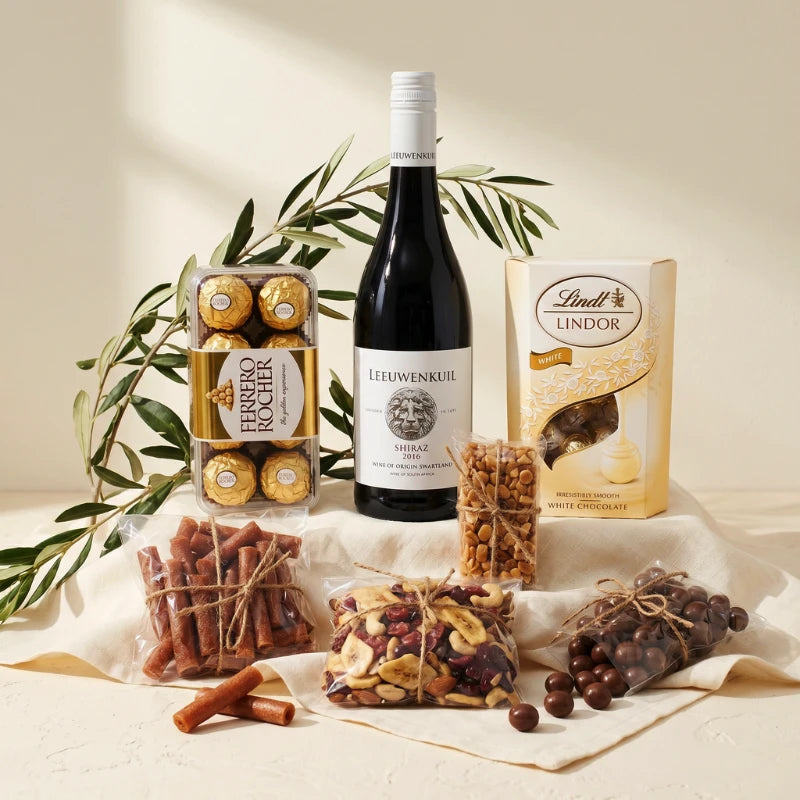 Family Picnic Time hamper styled with Ferrero Rocher, Leeuwenkuil Shiraz, Lindt Lindor White, meebos and trail mix, Fabulous Flowers and Gifts