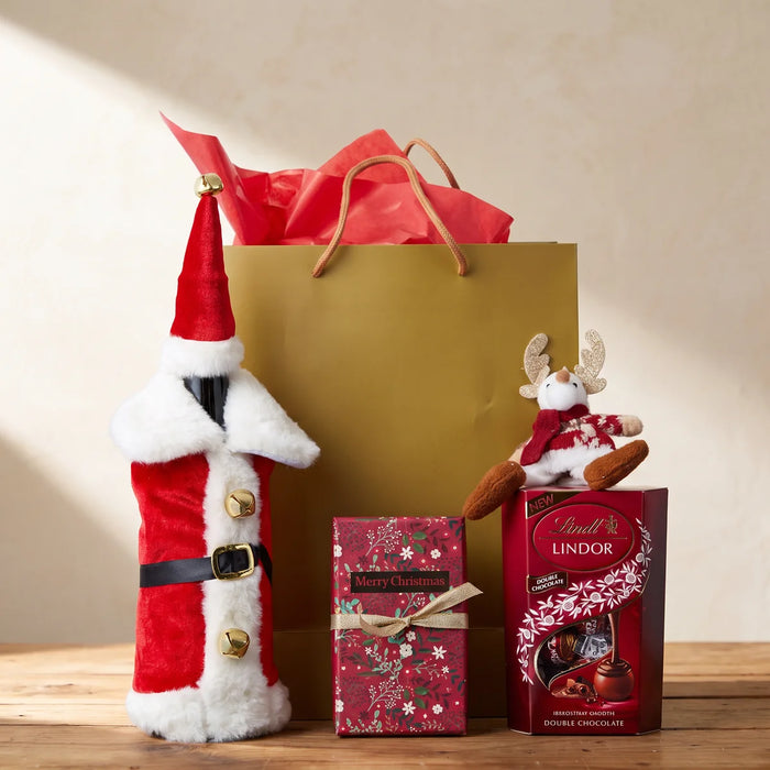 Red wine bottle in a plush Santa suit cover beside a gold gift bag, a floral Merry Christmas box and Lindt chocolates with a plush reindeer, Fabulous Flowers South Africa