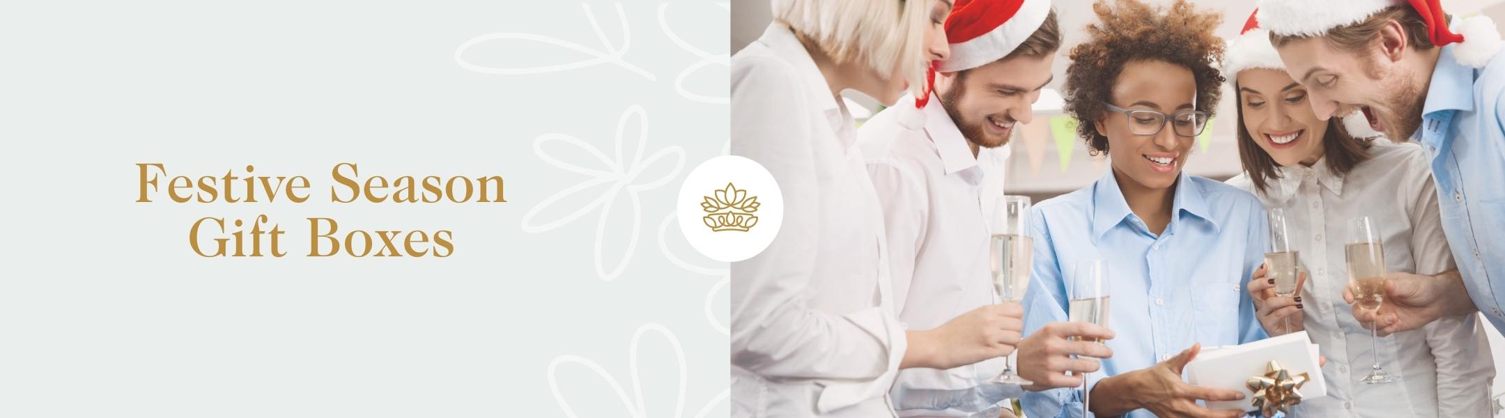 Festive Season Gift Boxes banner featuring a joyful group in holiday attire, celebrating with gift exchanges; Fabulous Flowers and Gifts.