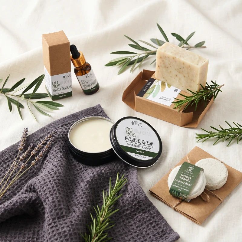 For Him Pamper Box with Oubos Beard & Shave Shea Butter Soap, Beard & Shave Oil, Olive Oil Soap and Dinaledi Shower Steamer on a grey waffle hand towel, Fabulous Flowers and Gifts