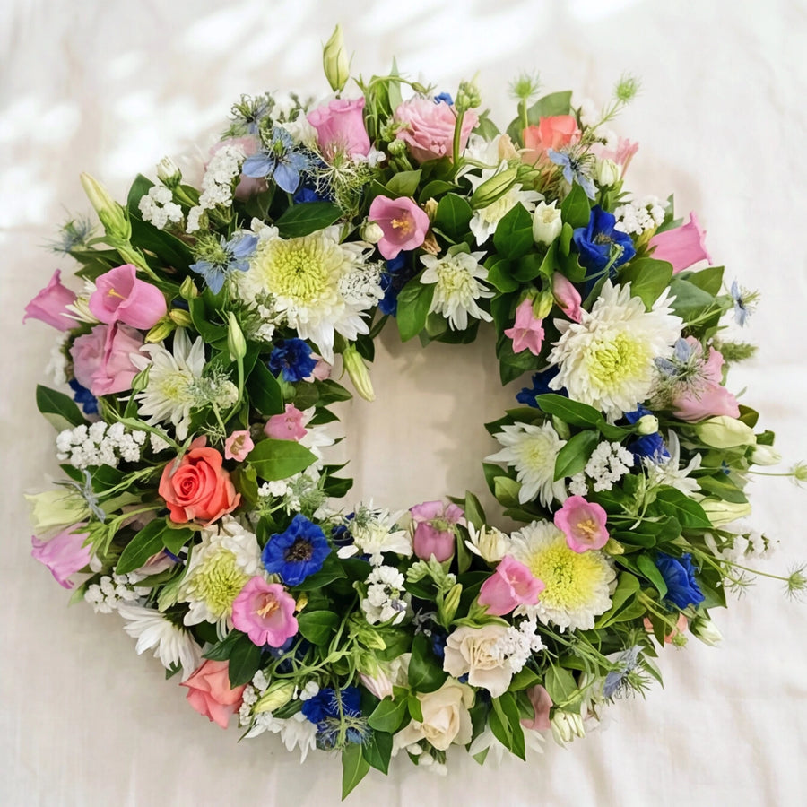 Forget Me Not sympathy wreath in pink, white and blue with lisianthus, chrysanthemums and delphinium