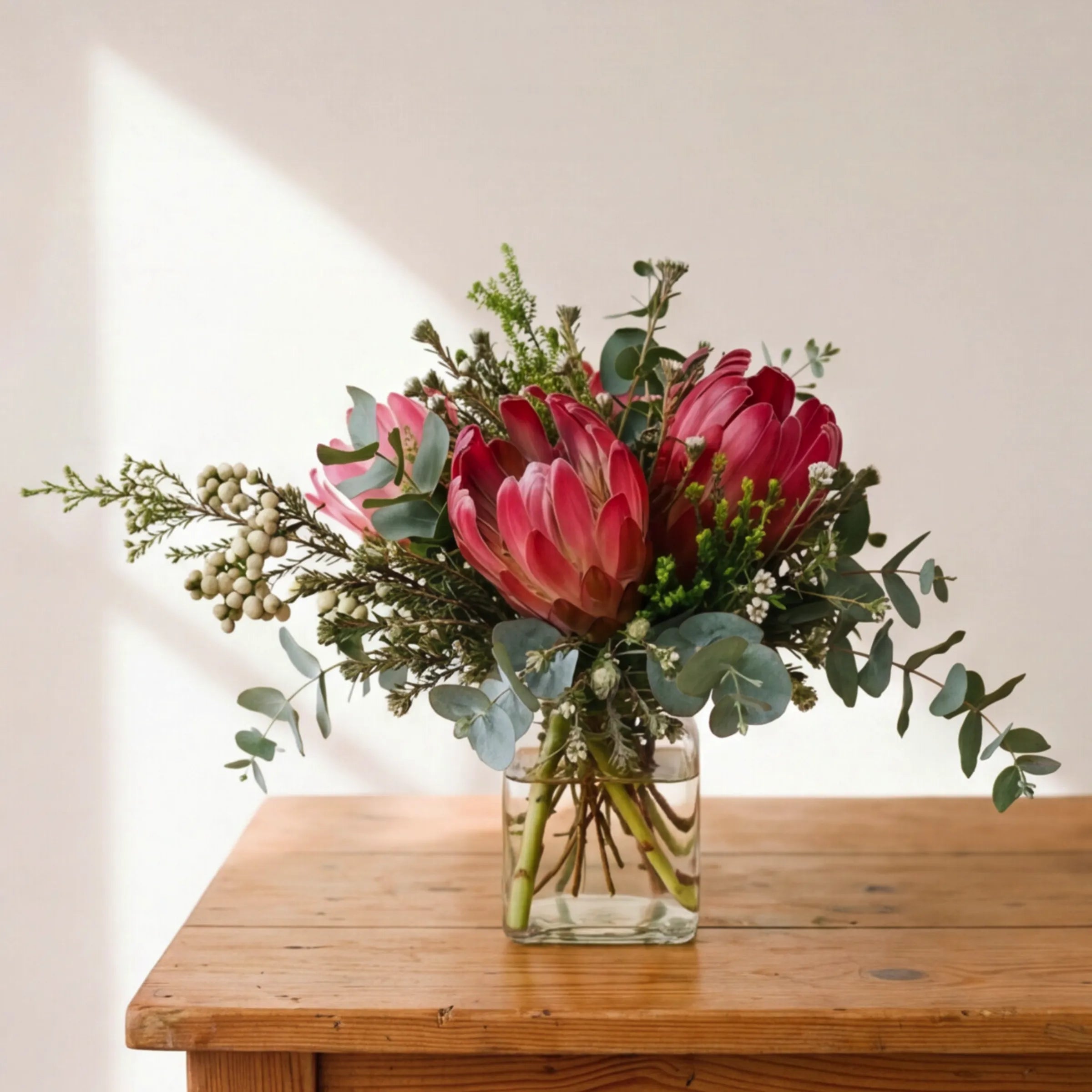 Fynbos in a Jar pink proteas, silver berzelia, waxflower and eucalyptus posy in a glass jar by Fabulous Flowers Cape Town