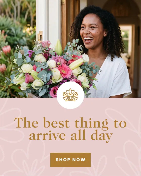 Smiling woman receiving a pink and white flower bouquet at her Cape Town front door