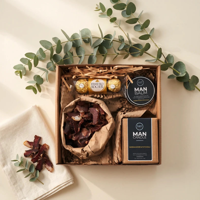 Gifts for a Man Hamper flat-lay with Soy Lites Sandalwood candle and balm, Ferrero Rocher and biltong, Fabulous Flowers and Gifts