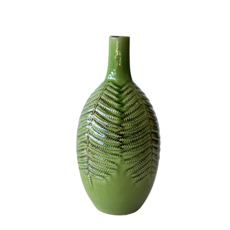 Green ceramic vase with leaf pattern on a white background