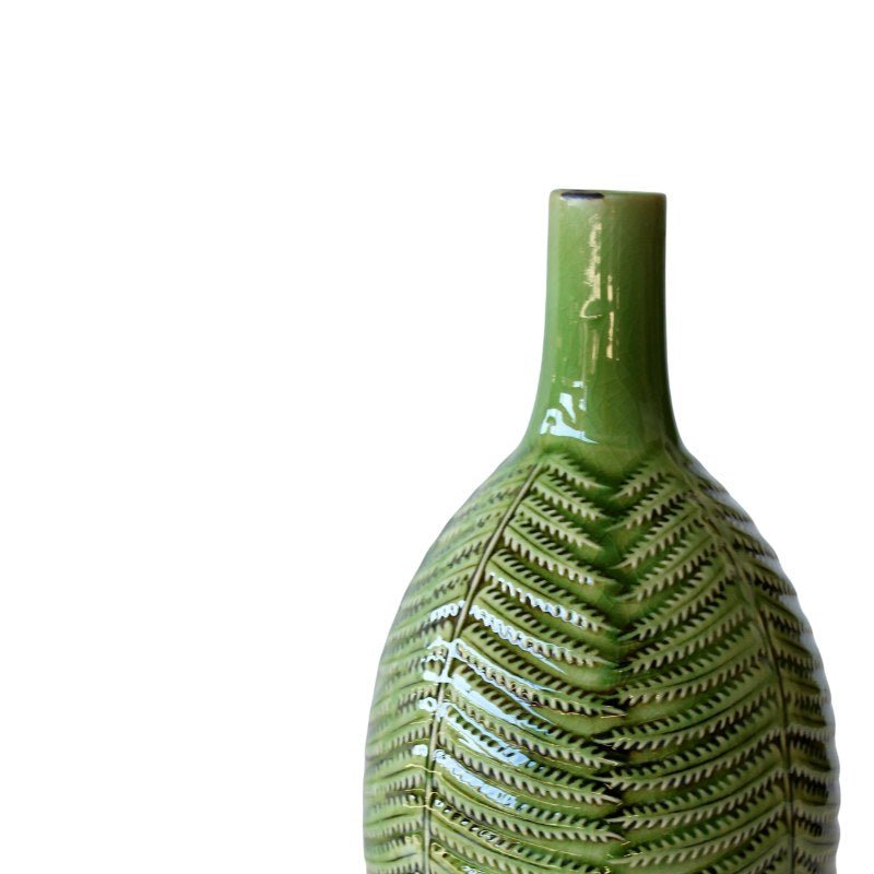 Green ceramic vase with leaf-like patterns on a white background