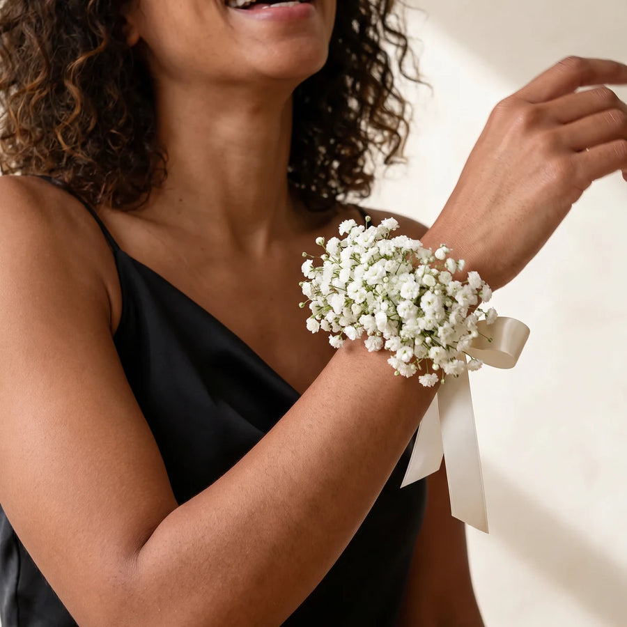 Woman in a black satin dress laughing and wearing a baby's breath wrist corsage, Fabulous Flowers South Africa
