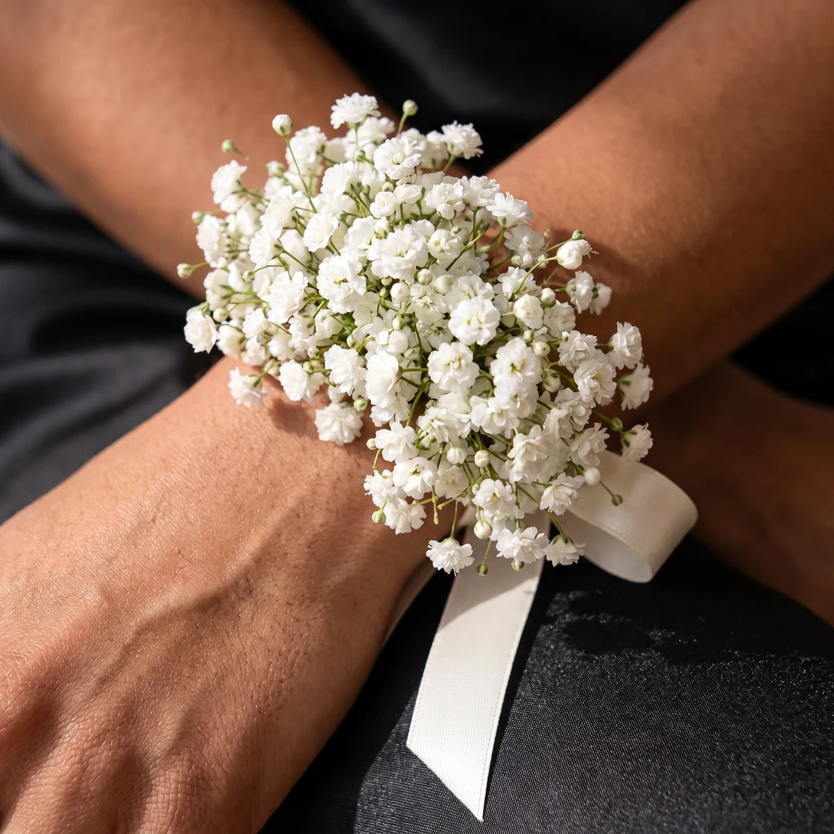 Close-up of a full gypsophila wrist corsage with ivory ribbon against black satin, Fabulous Flowers South Africa