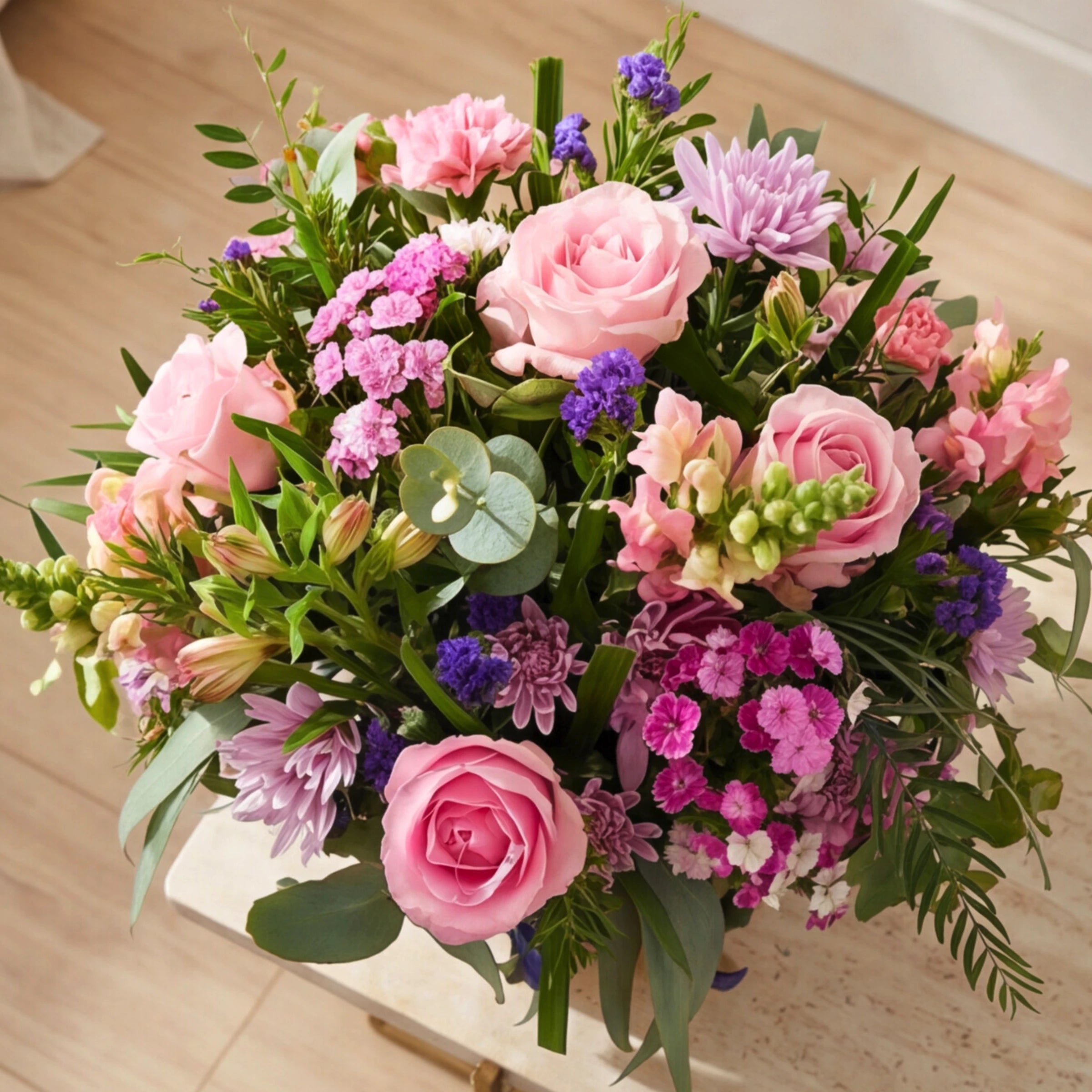 Overhead view of Harmony Flower Arrangement showing pink roses, purple statice, sweet william, lilac chrysanthemums, pink alstroemeria and snapdragons in a pastel pink and purple composition by Fabulous Flowers Cape Town