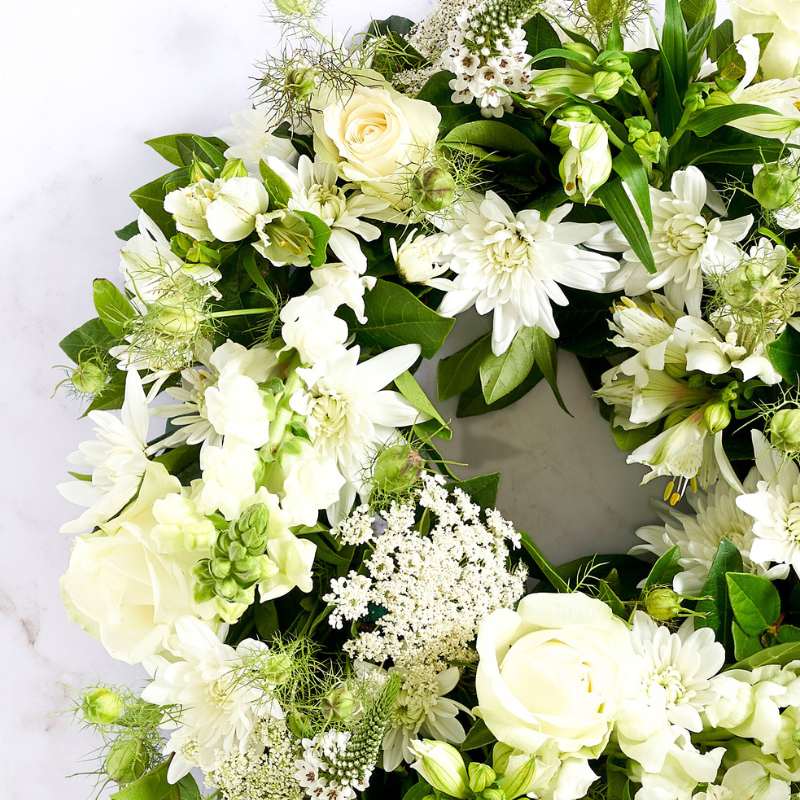 Close-up of Heavenly Grace White Wreath showing white lilies, roses and delicate foliage details