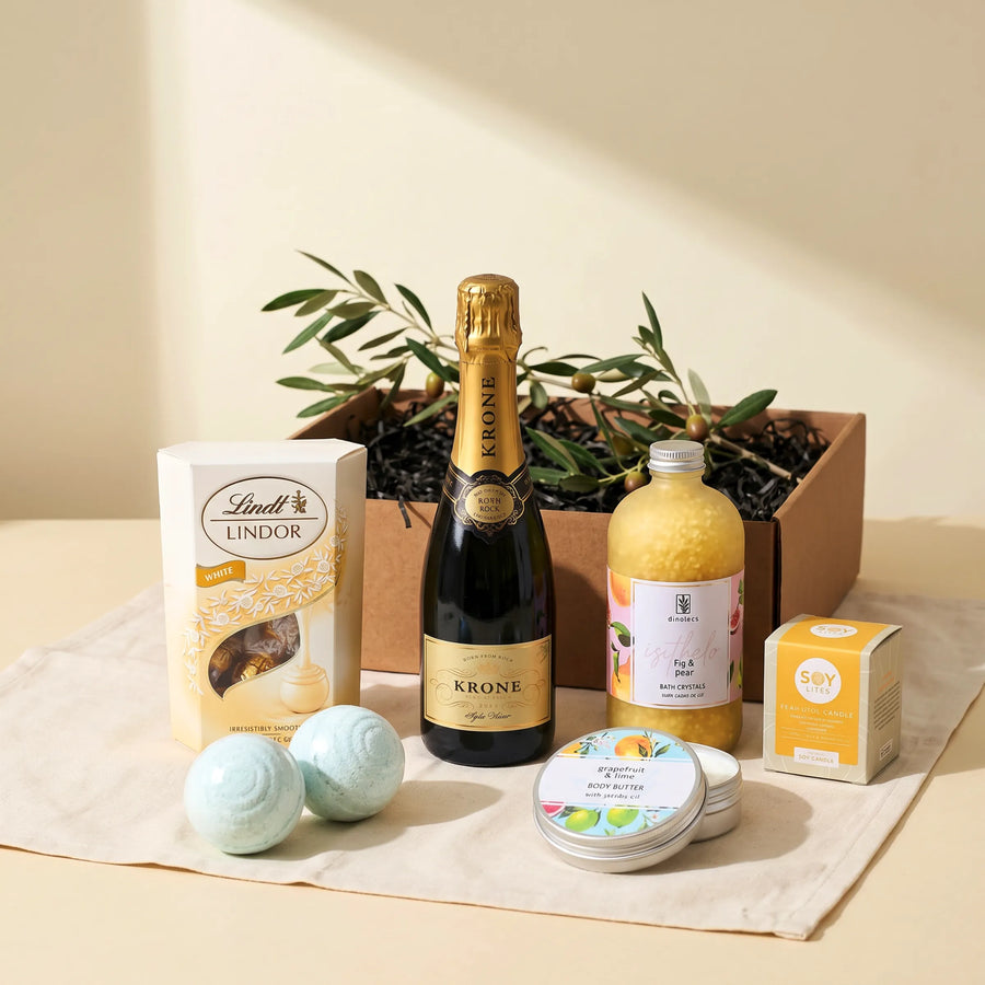 The Heavenly Harmony Hamper from Fabulous Flowers South Africa, a luxury pamper gift of Krone sparkling wine, Lindt Lindor white chocolate truffles, Grapefruit and Lime body butter, Fig and Pear bath crystals, two artisan bath bombs and a Soy Lites soy candle in a keepsake kraft gift box for nationwide delivery