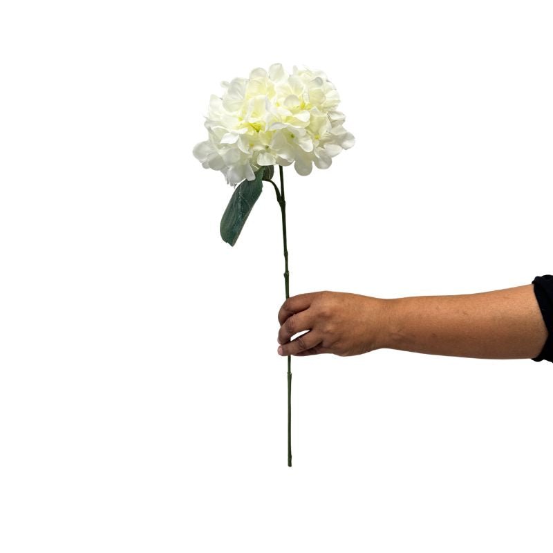 Hand holding a white artificial flower against a white background