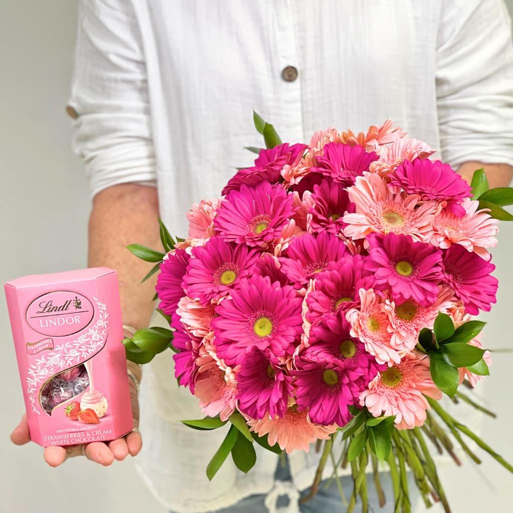 Florist holding Infinite Pink Gerbera Bouquet with Lindt Chocolates - Fabulous Flowers