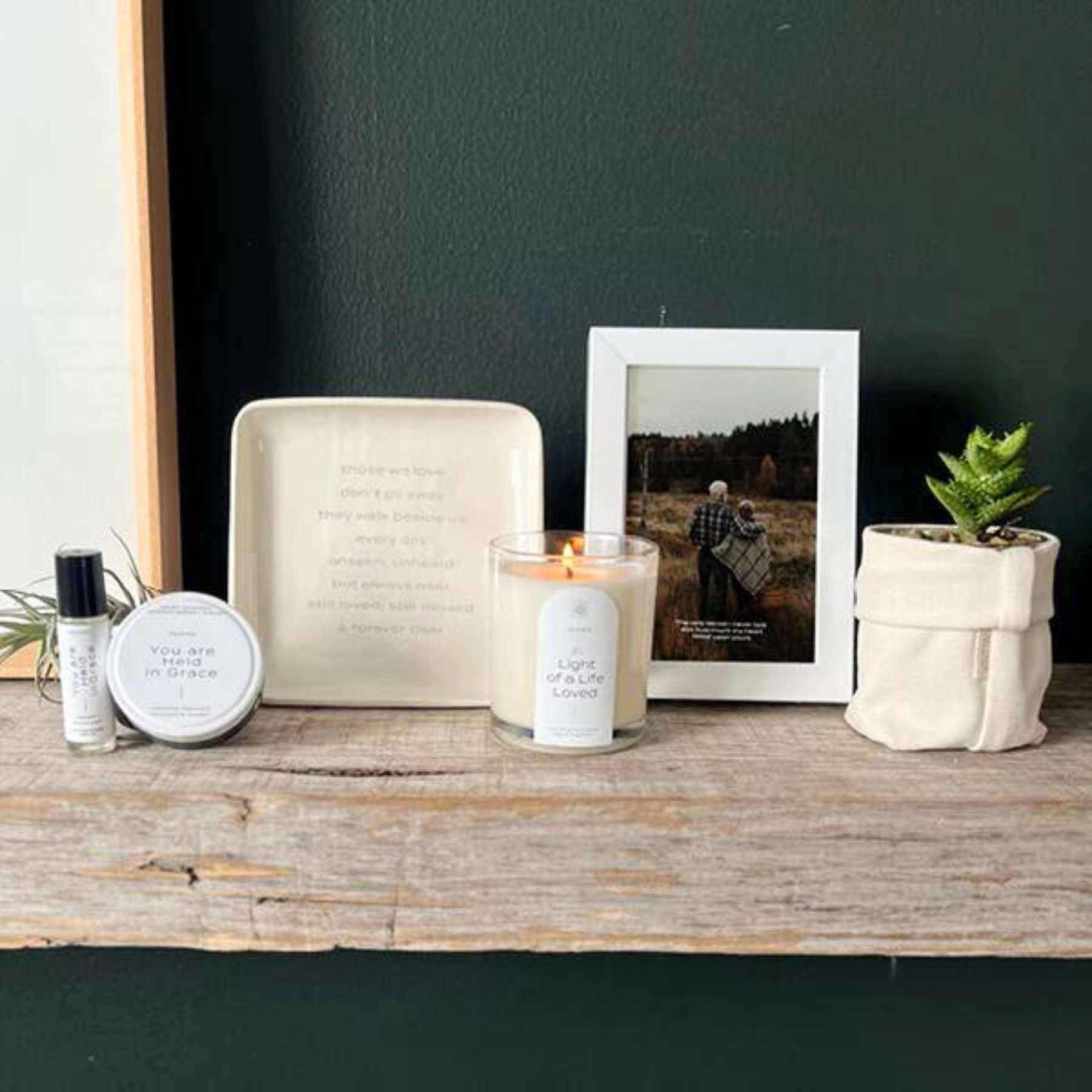 Stylish home ambiance set with LACUNA Frame featuring a peaceful countryside photograph, scented candle, and green plant, curated by Fabulous Flowers and Gifts for a warm, inviting home atmosphere.