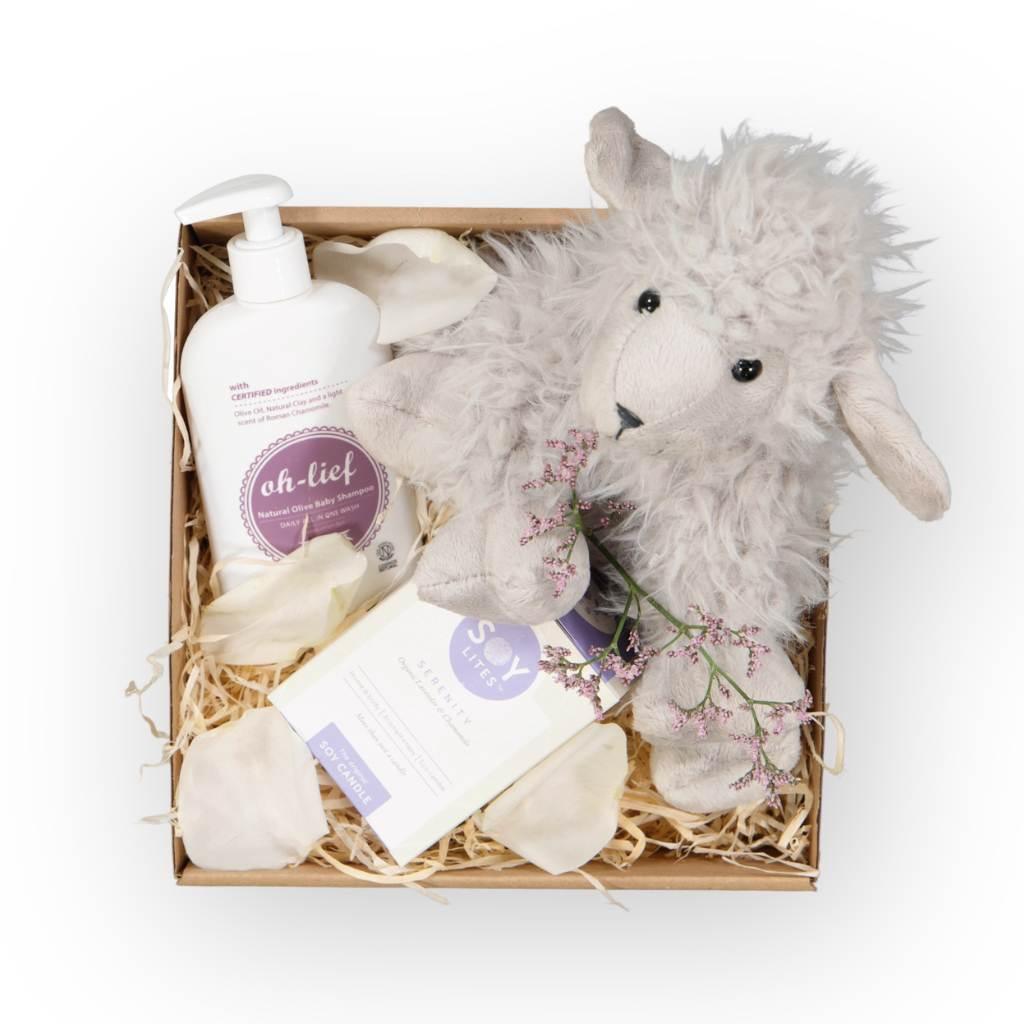 Close-up of baby box contents highlighting luxe detailing of fluffy lamb toy, baby shampoo and a candle - Fabulous Flowers