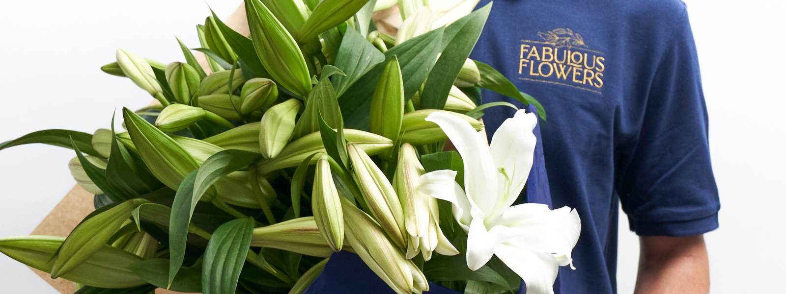 Beautiful bouquet of white Casa Blanca Lilies with a delivery man wearing Fabulous Flowers t-shirt
