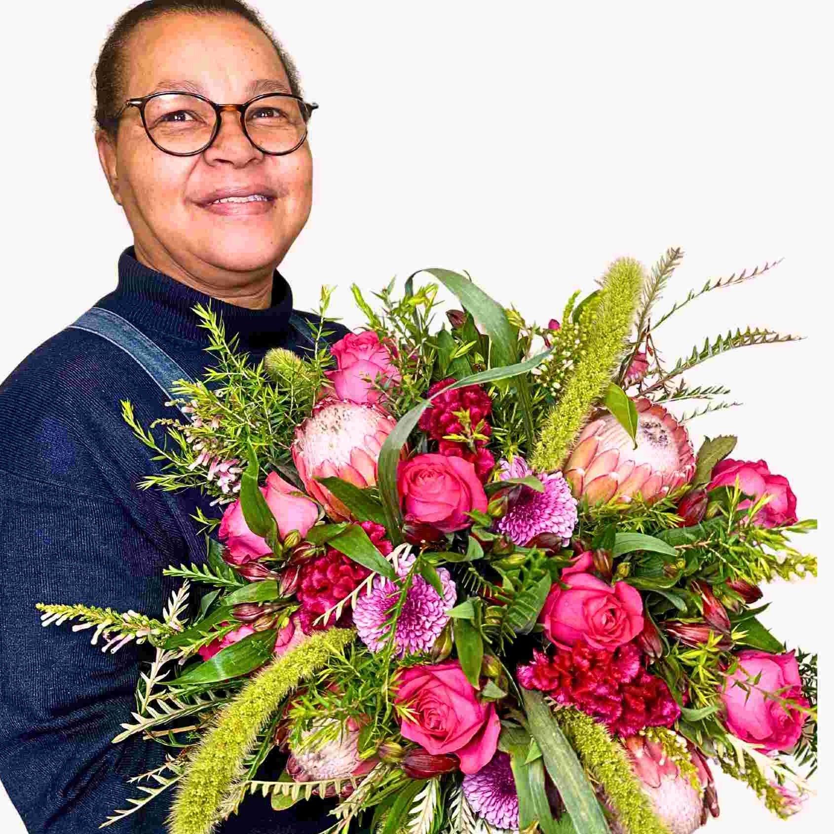 Lily, our happy florist presents her Lily's Flower Bouquet, a vibrant and lush arrangement of pink flowers and greenery, showcasing the quality and beauty offered by Fabulous Flowers and Gifts.