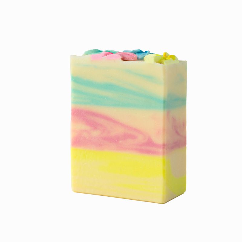 Side view of Mi&U Île de Soleil soap bar showing hand-piped pastel flowers and layered pastel stripes.