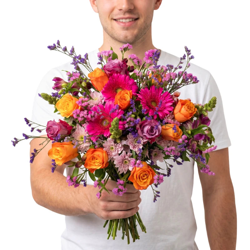 Man holding a vibrant bouquet of flowers against a white background