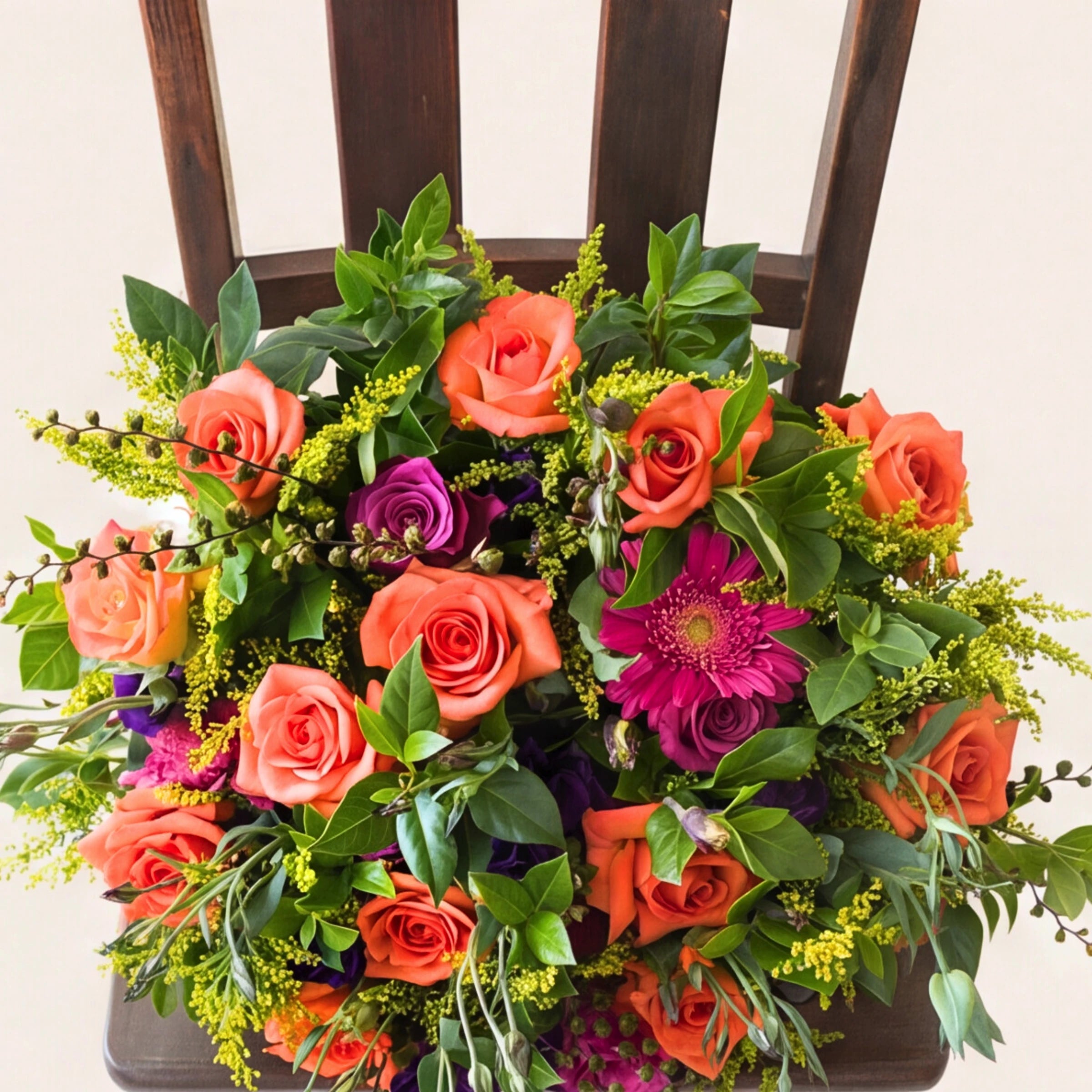 Top-down view of the Lush and Lovely bouquet, orange roses, magenta gerbera and purple blooms