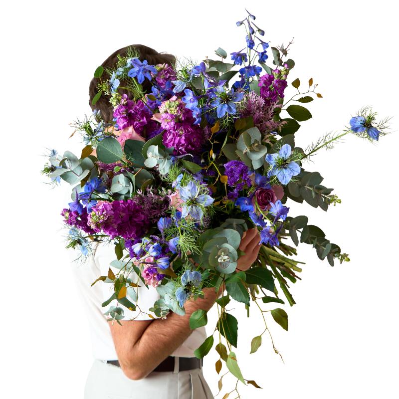 Person holding a large bouquet of flowers with a white background