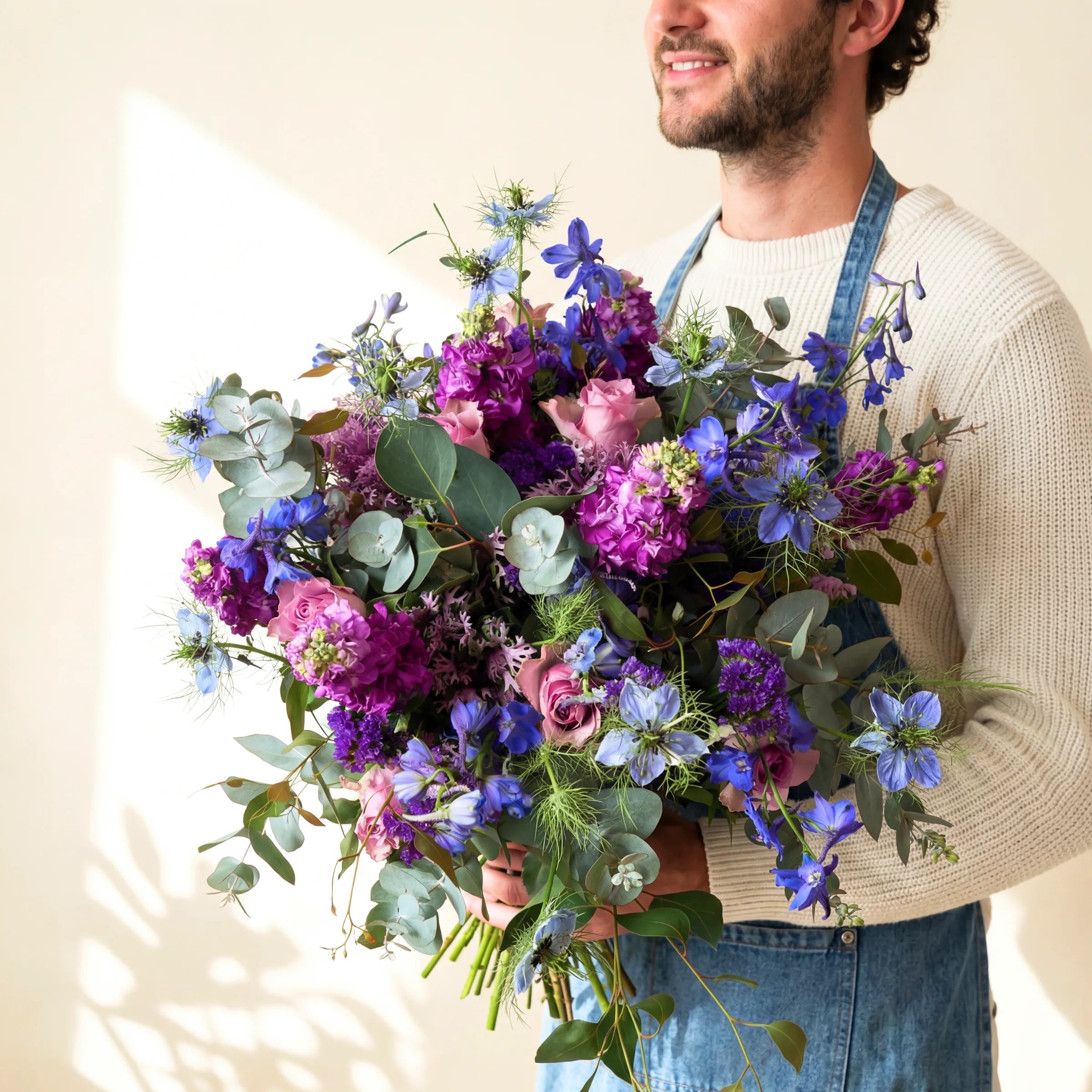 Cape Town florist holding the lavender garden bouquet of lilac roses, purple stock and blue delphinium, hand-tied since 1999