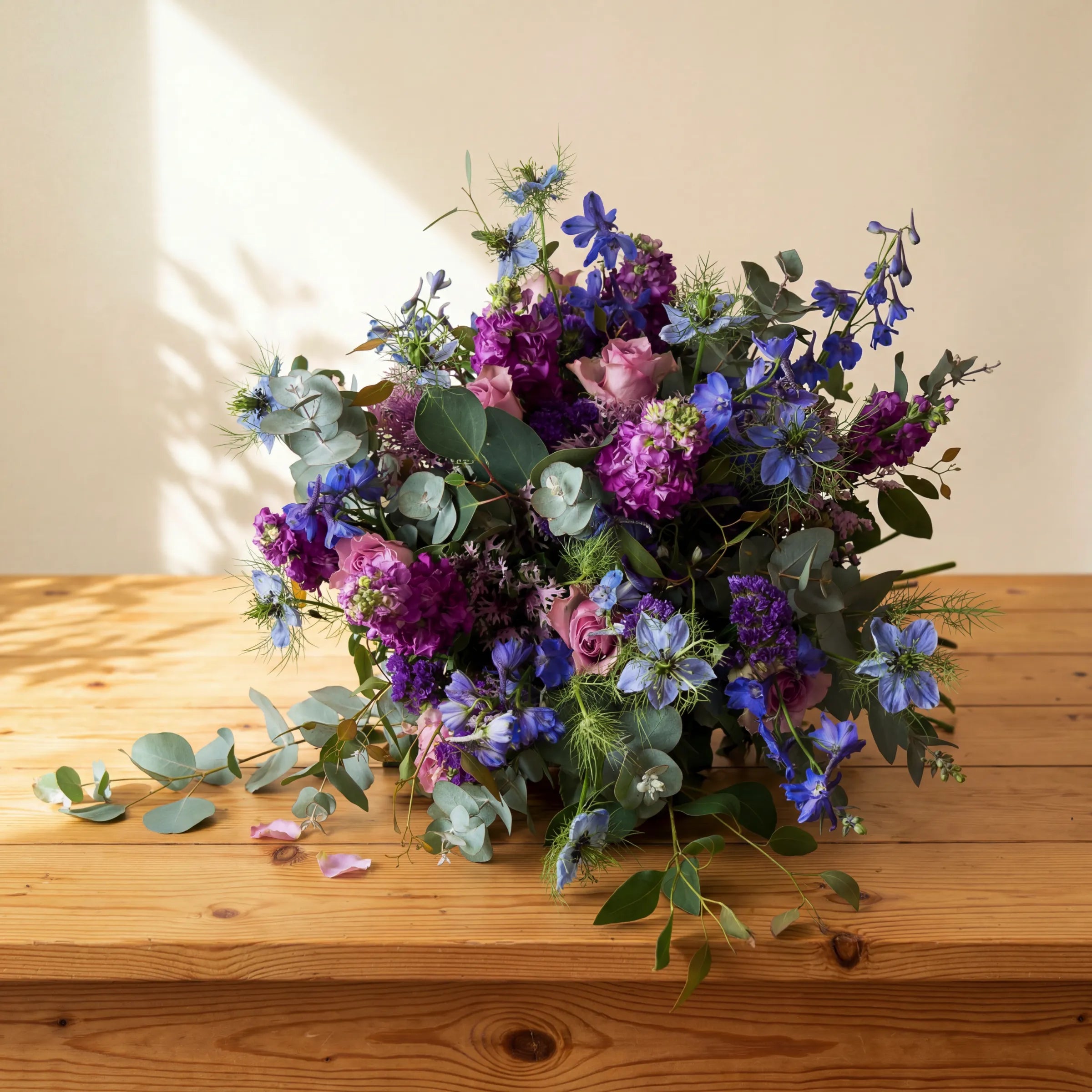 Luxury lavender garden bouquet of purple stock, blue nigella and lilac roses resting on a pine table, Fabulous Flowers
