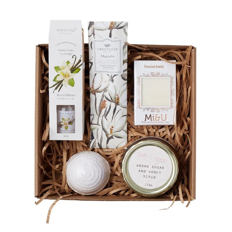 Gift set with bath products including a candle, soap, and bath salts on a white background