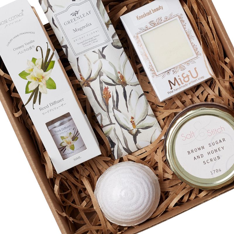 Gift basket with various beauty products including a diffuser, soap, and scrub.
